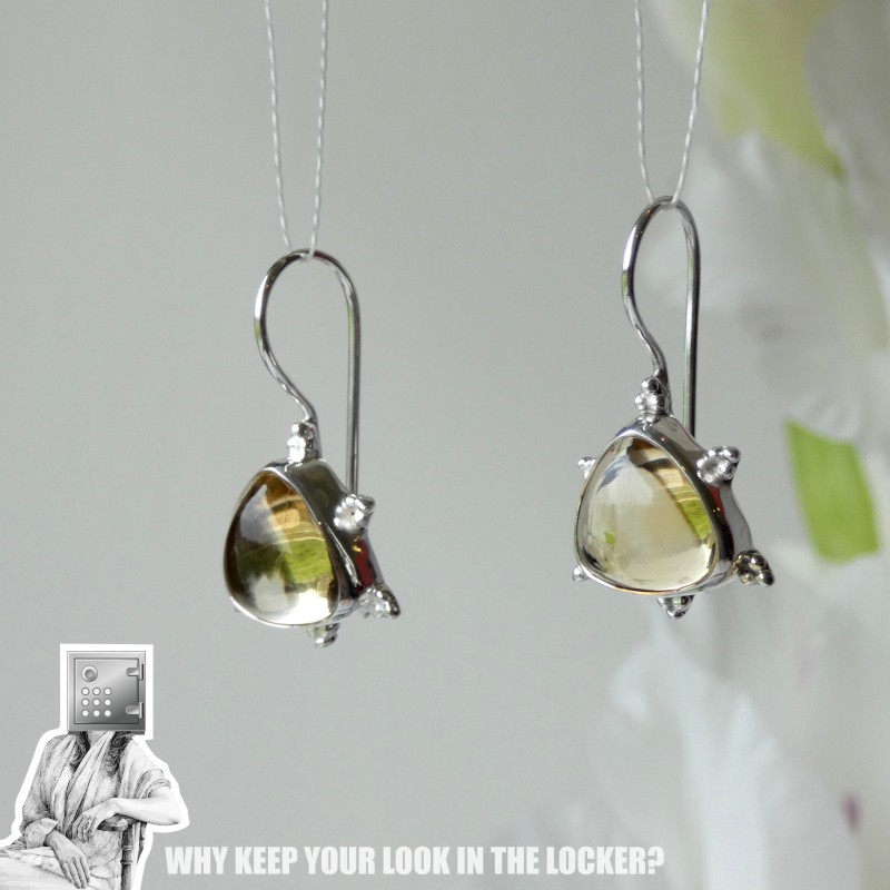 A pair of elegant silver earrings featuring teardrop-shaped gemstones, displayed against a neutral background.