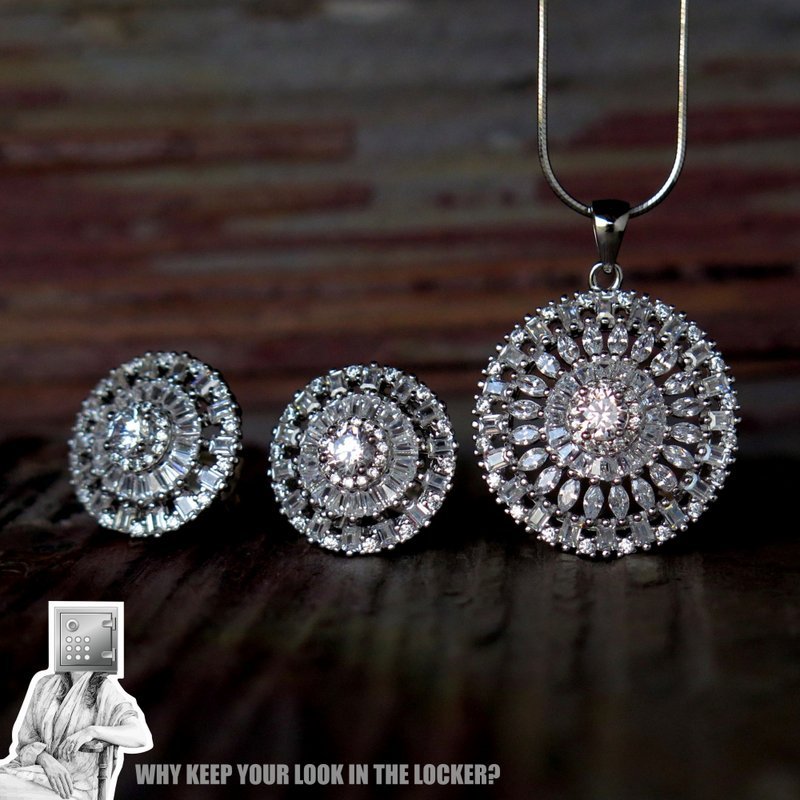 A close-up view of a jewelry set featuring a large pendant and matching earrings, all embellished with sparkling gemstones, displayed on a rustic wooden surface.
