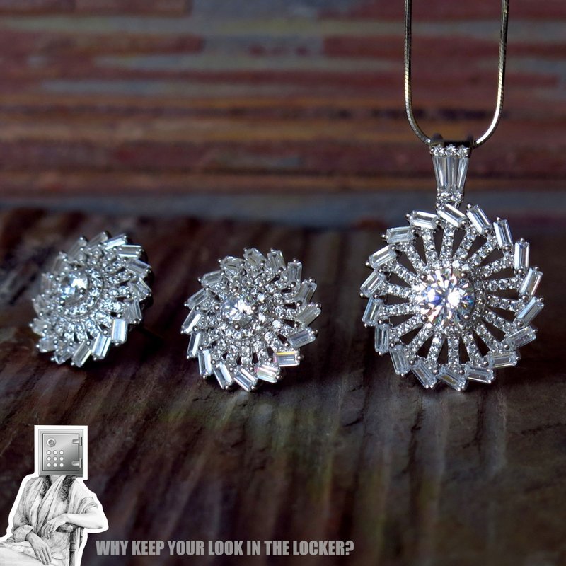 A set of elegant silver jewelry featuring a pendant and matching earrings, adorned with sparkling gemstones, displayed on a rustic wooden surface.