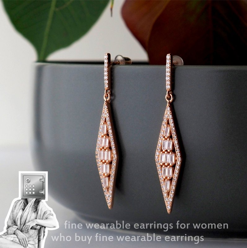 A pair of elegant fine wearable earrings for women, designed in a diamond shape with sparkling accents, displayed on a grey ceramic pot.