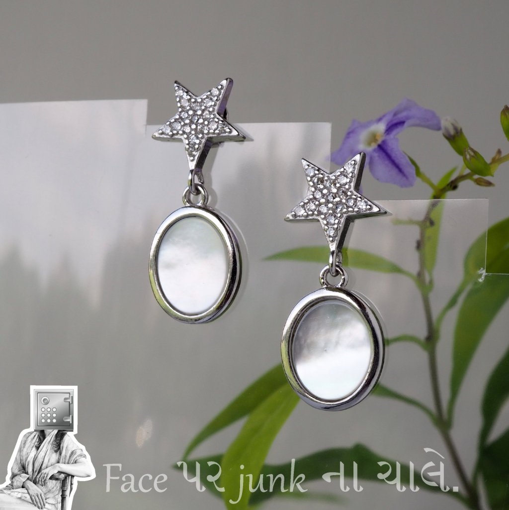Silver star-shaped earrings with oval mother-of-pearl pendants, displayed against a soft floral background.
