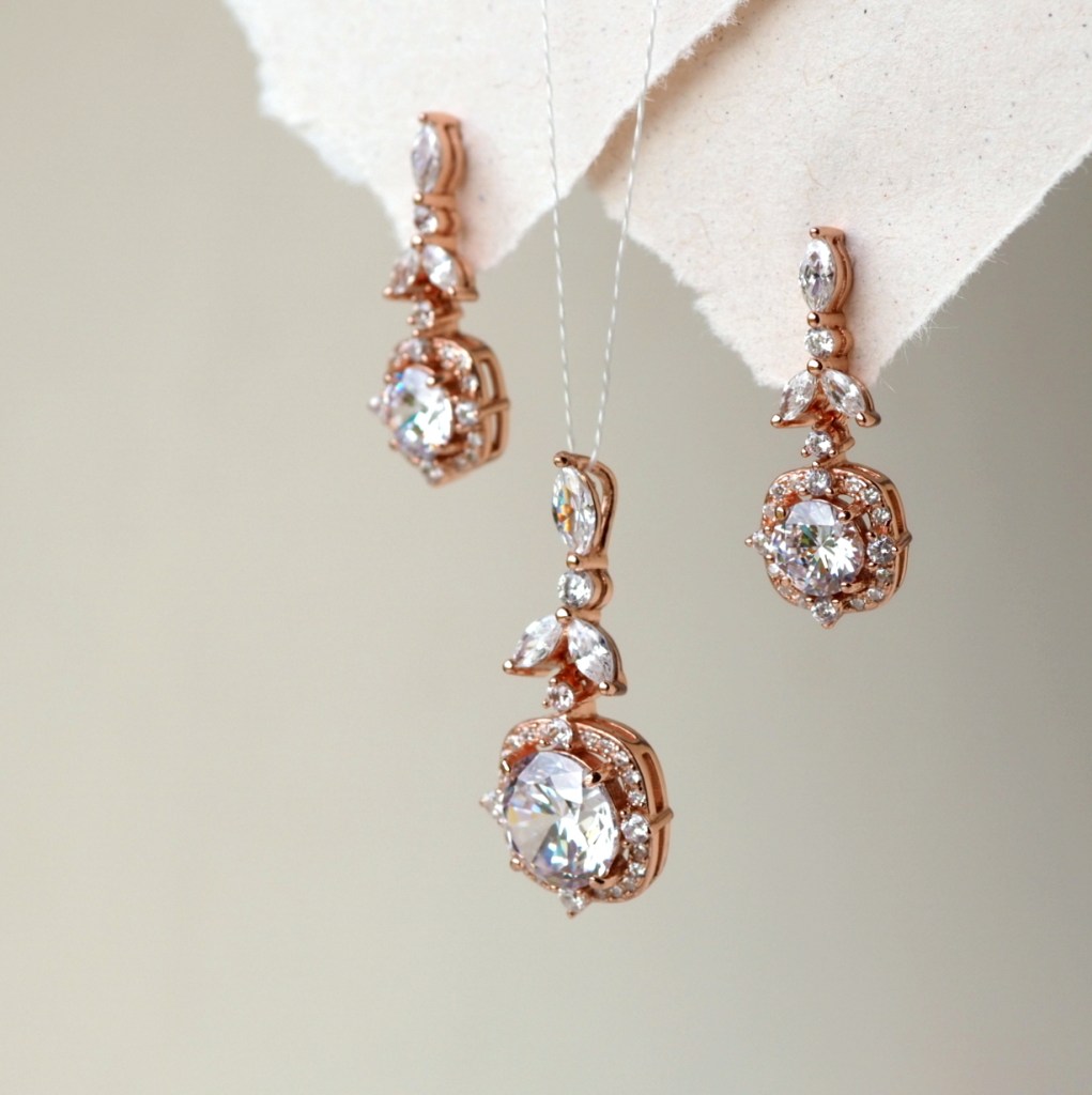 A close-up of elegant rose gold earrings featuring sparkling gemstones and intricate designs.